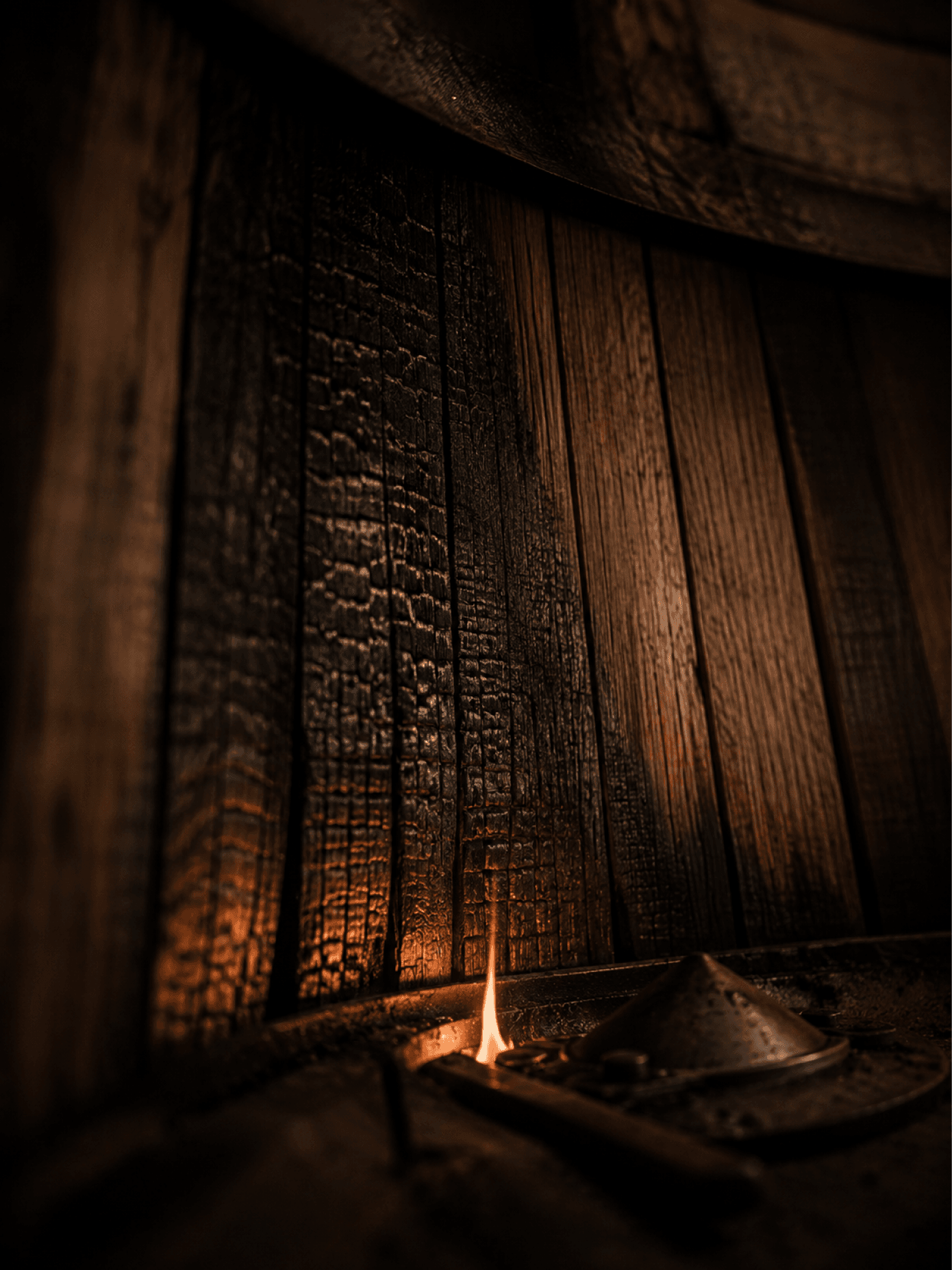 Charred French oak staves lit by a single candle